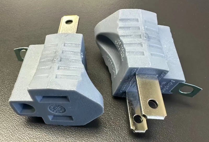 Commercial Electric 15A single-outlet grounding adapter, gray plastic, two units shown