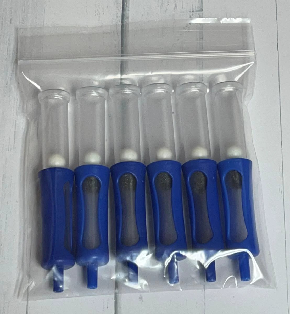 Set of six blue and clear plastic tools in a clear plastic bag on a white background