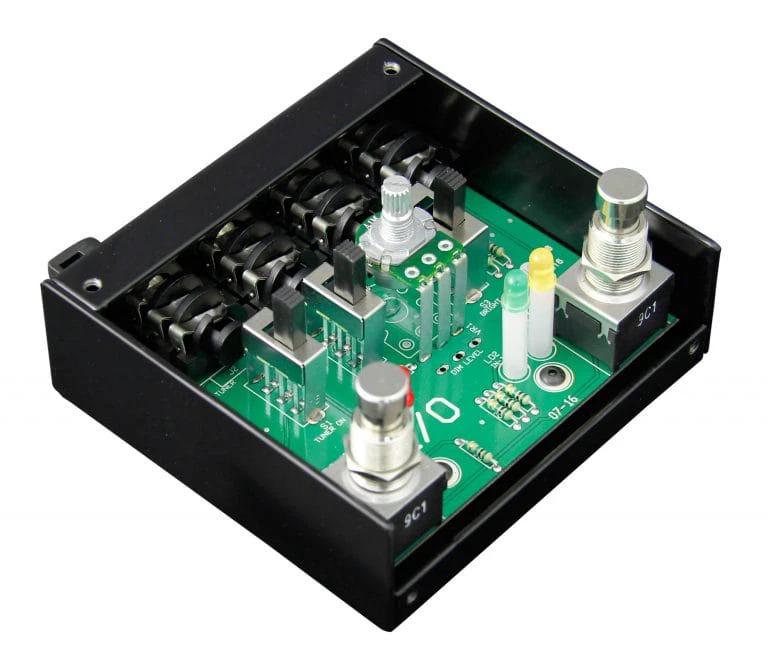 Electronic control module with green circuit board and metal components on a white background