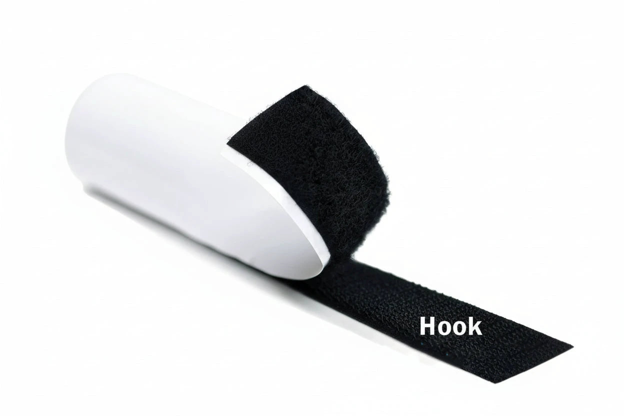 Black hook and loop tape with a hand holding a white pull tab on a white background.